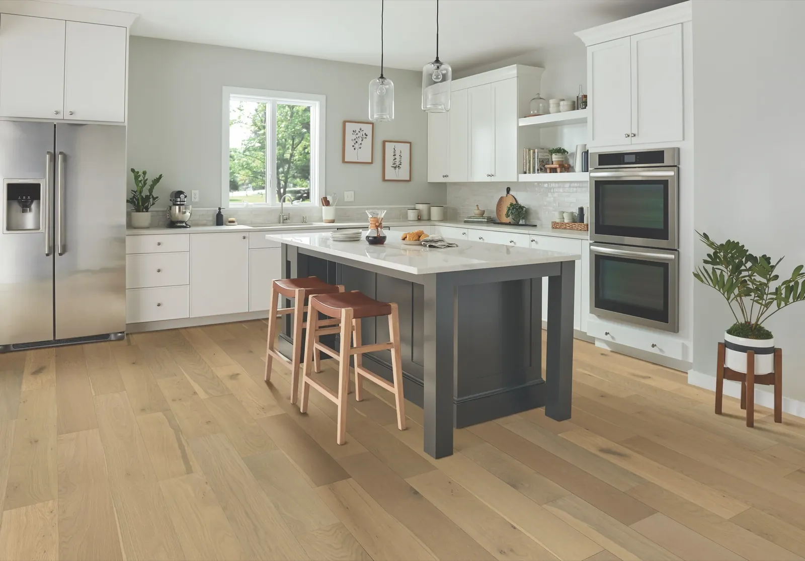 Bright kitchen with cream cabinets, a gray island and warm wood flooring